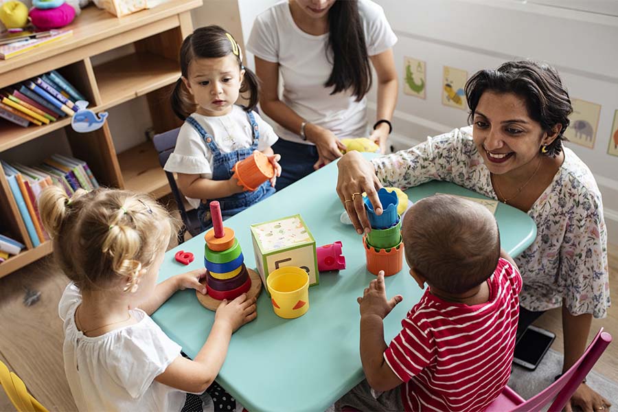 Specialized Business Insurance - View of Cheerful Teacher Playing with a Group of Young Kids at a Daycare Center