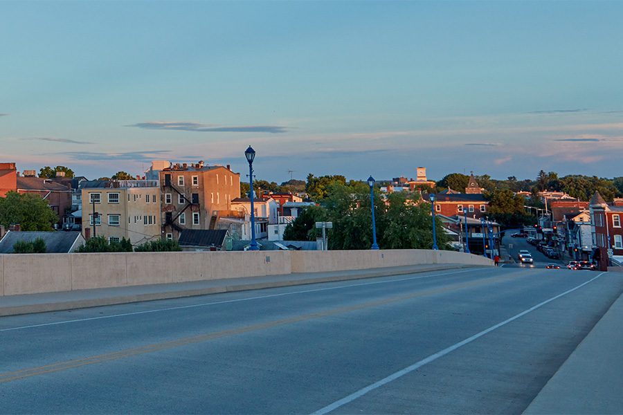 Phoenixville, PA - View of Buildings and Homes in Downtown Phoenixville Pennyslvania from a Bridge Road at Sunset with a Clear Blue Sky